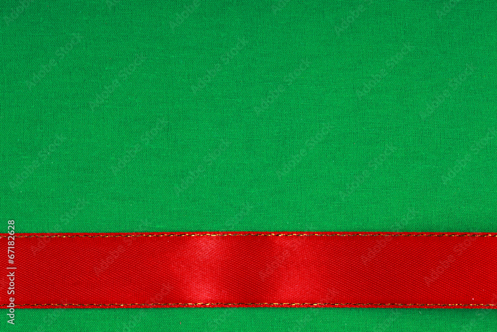 red ribbon on green fabric background with copy space.
