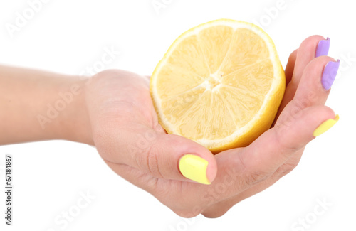 Female hand with stylish colorful nails holding fresh lemon,