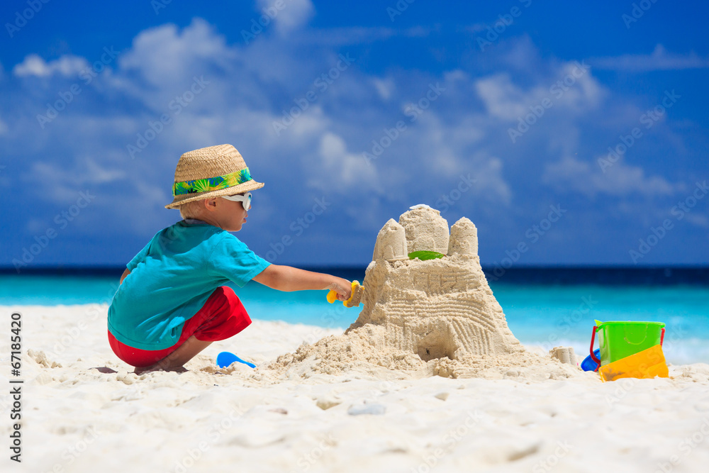 child building sand castle on tropical beach child building sand castle on tropical beach