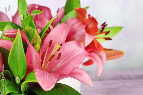 Beautiful lily in crate on table on bright background