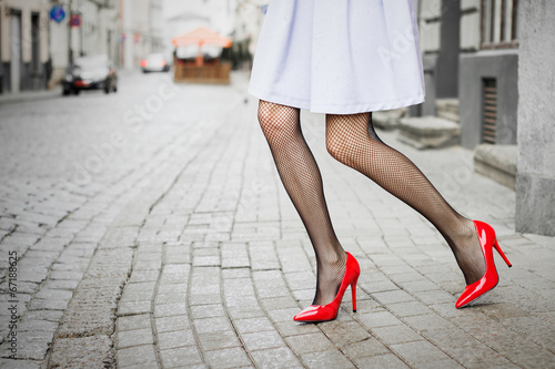 Woman wearing red high heel shoes in city