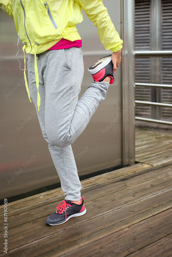 Female runner stretching leg before running Female runner stretching leg before running