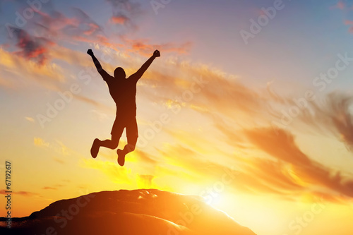 Fotografia Happy man jumping for joy on the peak of the mountain. Success