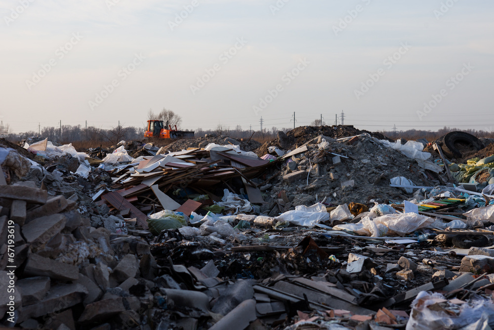 Garbage on the landfill and working bulldozer