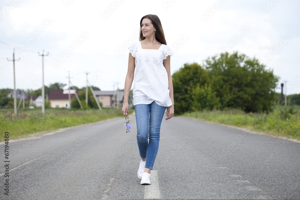 Young woman running along a country road Young woman running along a country road
