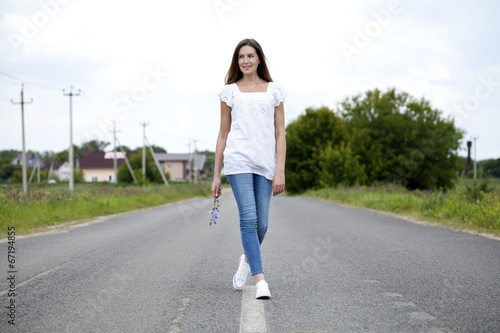 Young woman running along a country road © Andrey_Arkusha