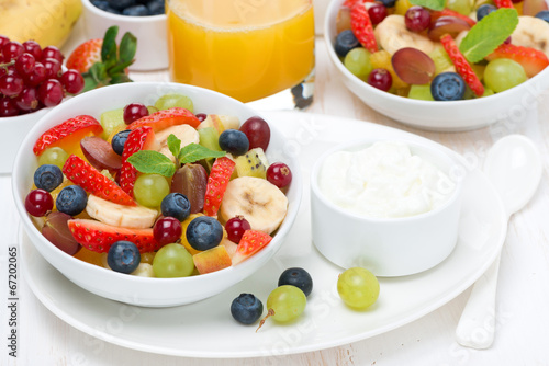 Fresh fruit and berry salad and cream for breakfast
