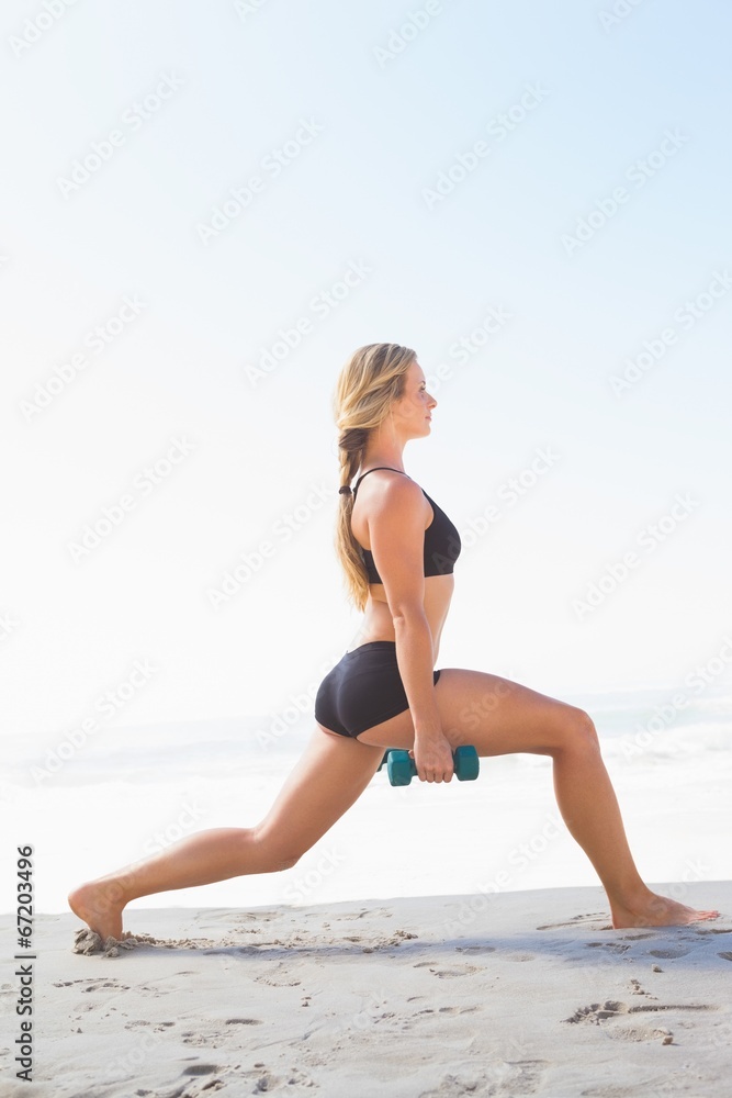 Fit blonde doing weighted lunges on the beach Fit blonde doing weighted lunges on the beach