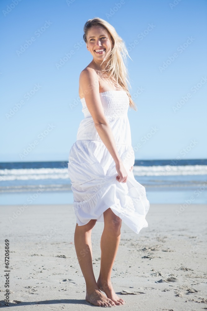 Woman in white dress smiling on the beach