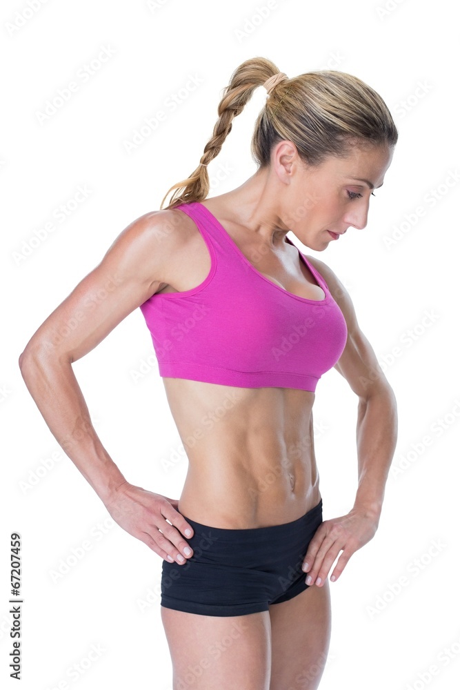 Female bodybuilder posing in pink sports bra Female bodybuilder posing in pink sports bra