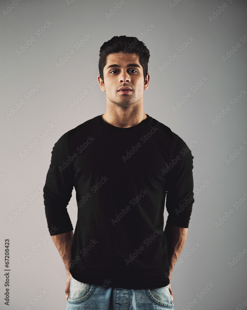 Handsome young hispanic guy posing on grey background Handsome young hispanic guy posing on grey background