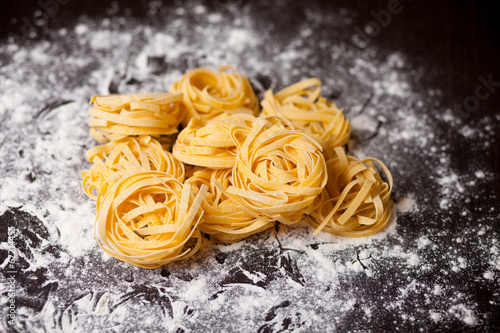 Raw pasta tagliatelle on table