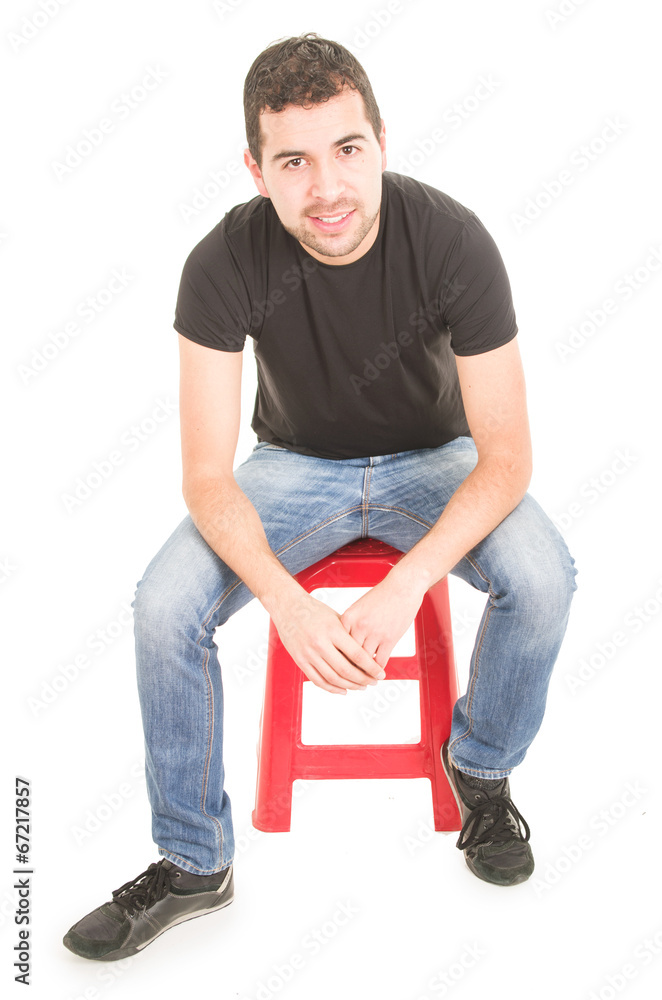 young man sitting on red stool young man sitting on red stool