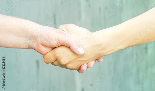 shaking hands of a young girl and an old woman