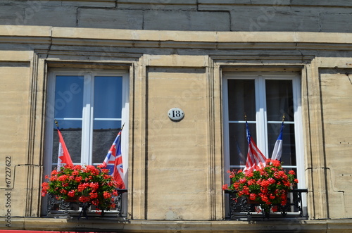 Fototapeta Naklejka Na Ścianę i Meble -  Jadinières de géraniums et drapeaux alliés
