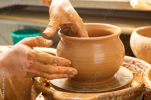 hands of a potter, creating an earthen jar