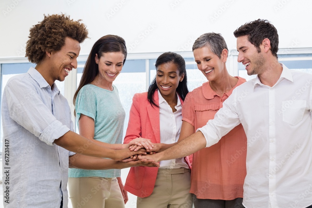 Casual business team putting hands together Casual business team putting hands together
