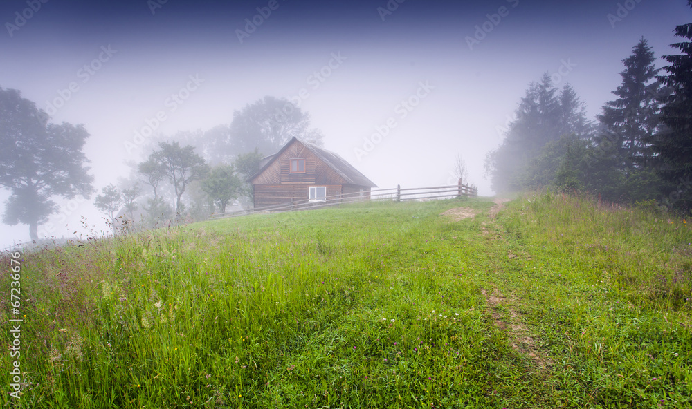 Foggy summer morning in the mountain village.