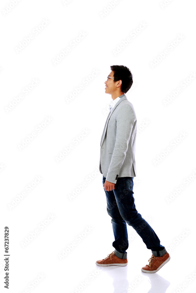 Full body side view of a fashion man walking forward Full body side view of a fashion man walking forward