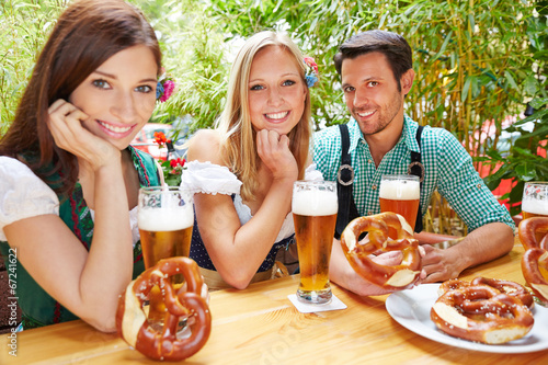 Freunde mit Bier und Brezel im Biergarten photo