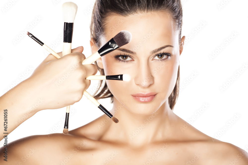 Beautiful woman with makeup brushes near her face Beautiful woman with makeup brushes near her face