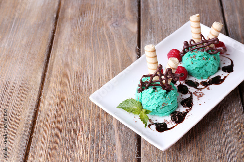 Tasty ice cream with chocolate decorations and sauce plate,