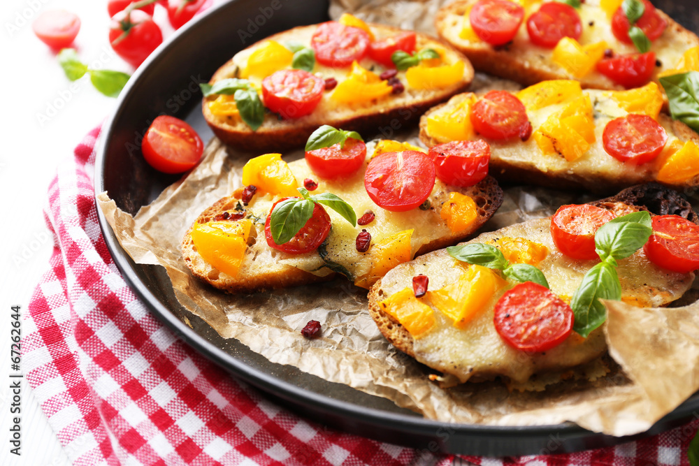 Tasty bruschetta with tomatoes in pan, on table Tasty bruschetta with tomatoes in pan, on table