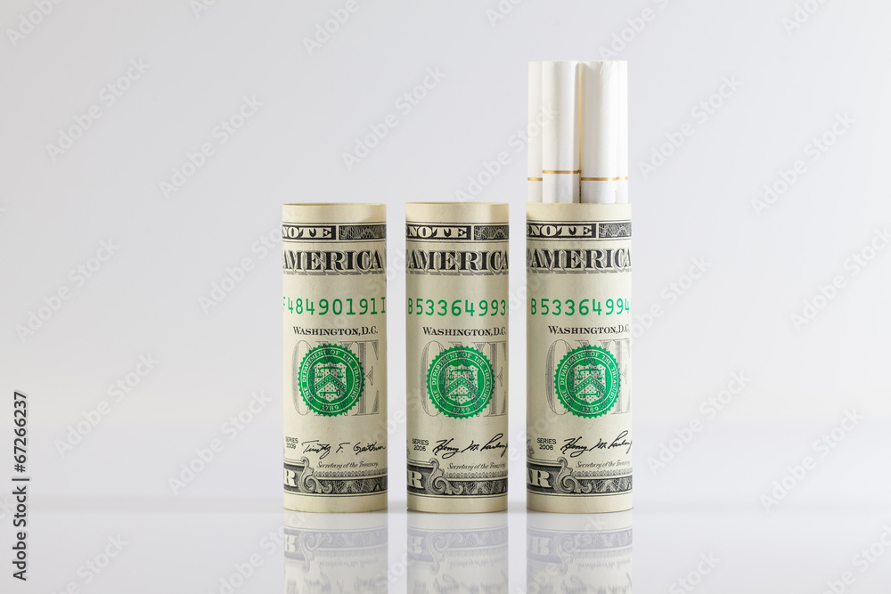 Rolls of dollar bills and a long cigarettes Rolls of dollar bills and a long cigarettes