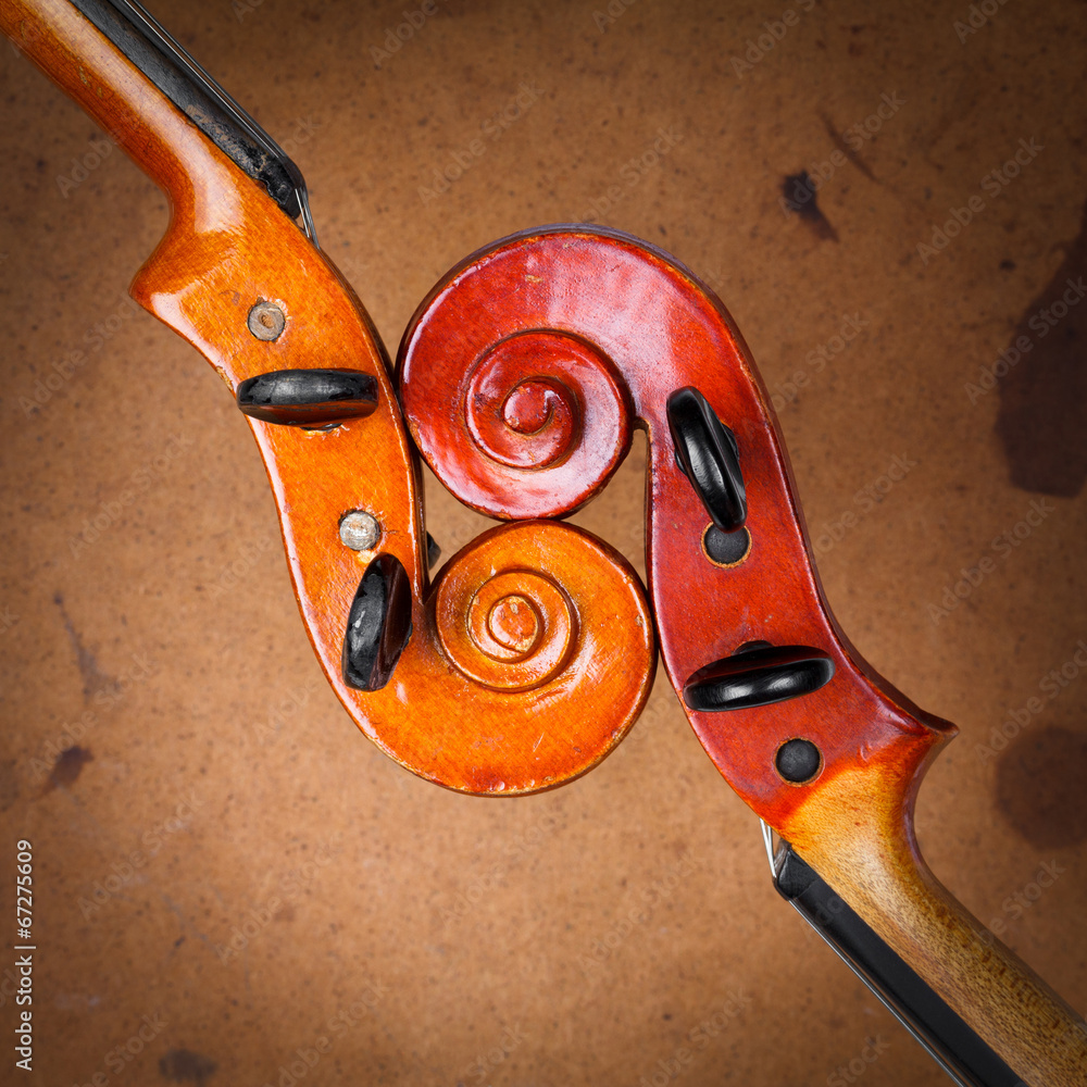 Fototapeta premium Two old violin scrolls detail over grunge background