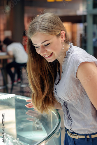 Blonde girl considers jewelry in the store photo