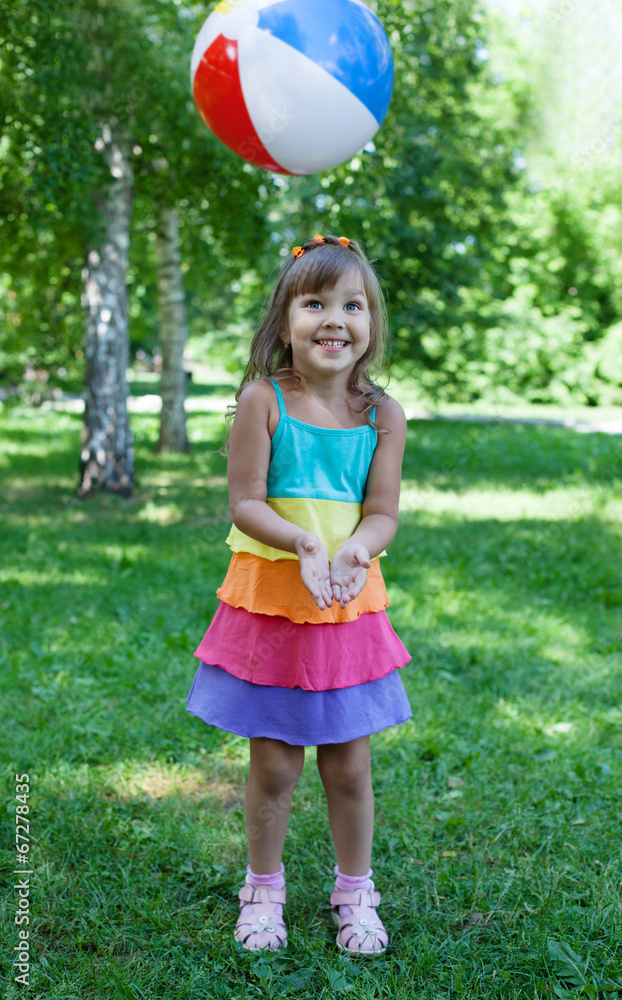 Happy girl catching ball outdoors