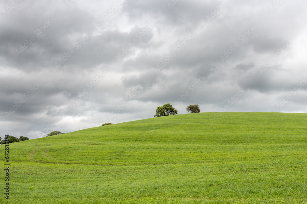 Dark clouds over a grass hill (center)