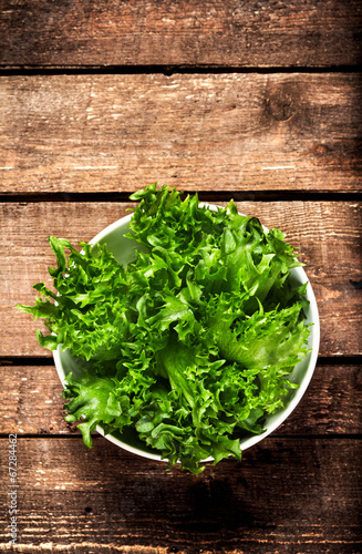 Fresh green salad in a bowl on wooden background - Lettuce Sala