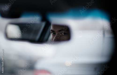 Bilde på lerret Man looking in the rear view mirror while driving