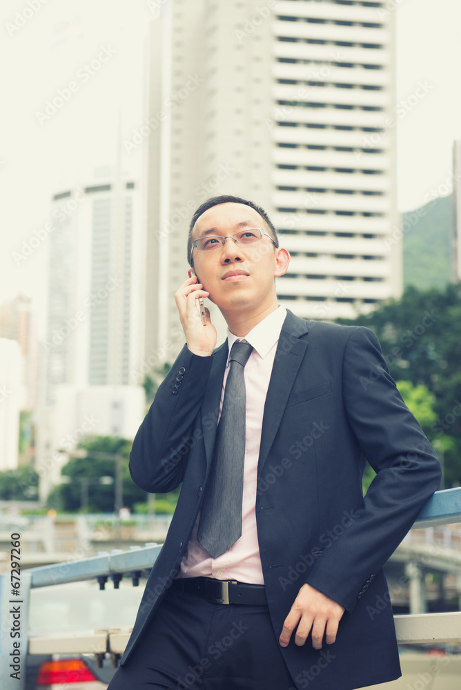 hong kong chinese businessman on a phone in busy central distric hong kong chinese businessman on a phone in busy central distric