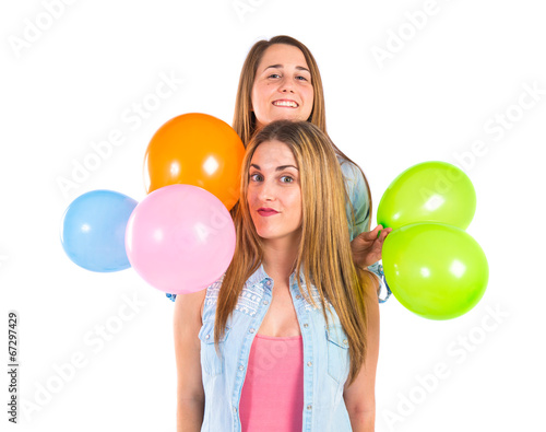 Friends with many balloons over white background © luismolinero