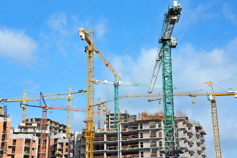 Crane and building construction site against blue sky