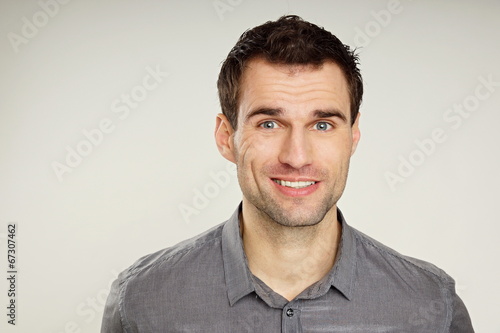Portrait of a handsome smiling man at grey shirt