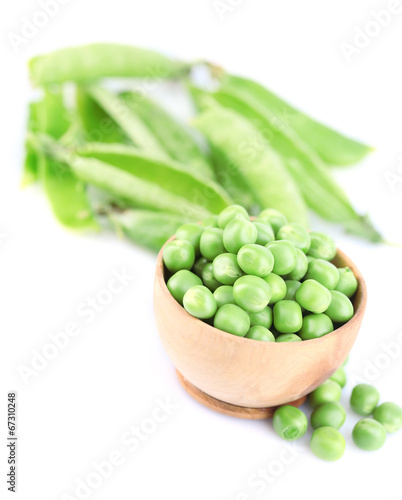Fresh green peas in wooden bowl, isolated on white background