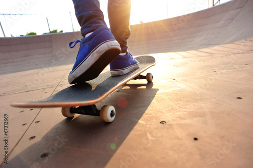  skateboarding woman legs at sunrise skatepark 
