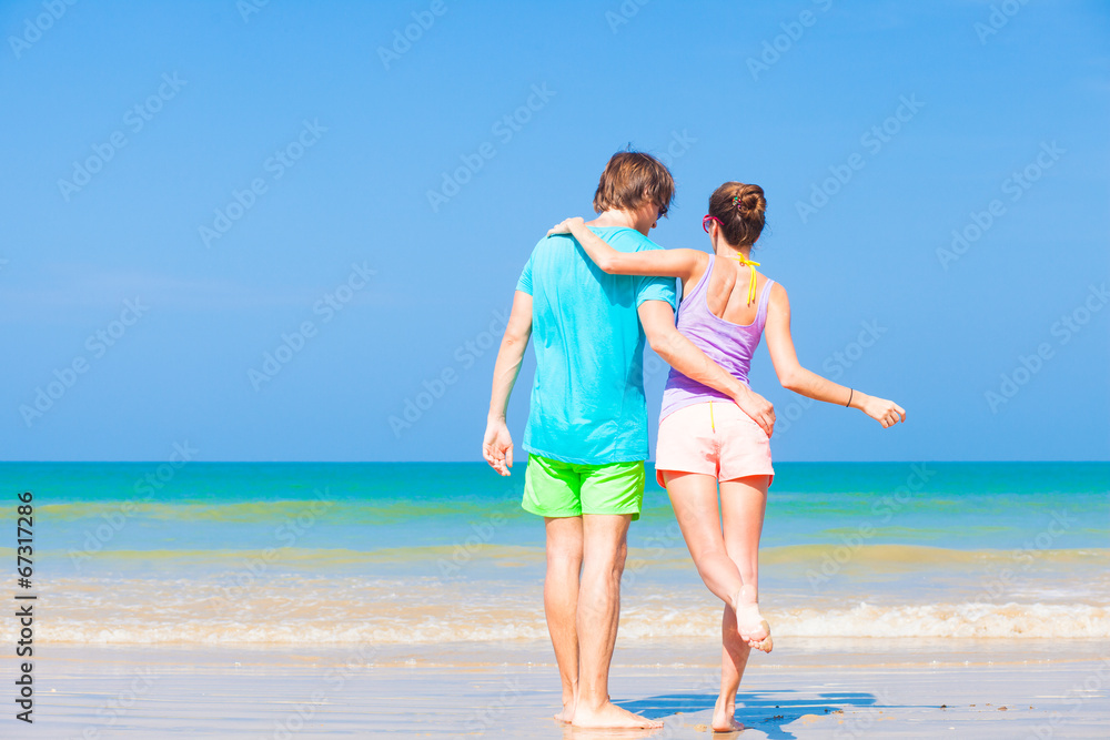 happy young couple in bright clothes and sunglasses having fun