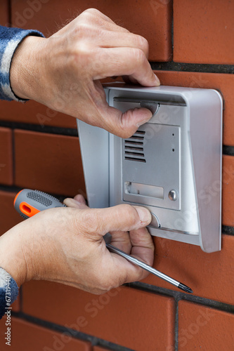 Male hands repairing intercom