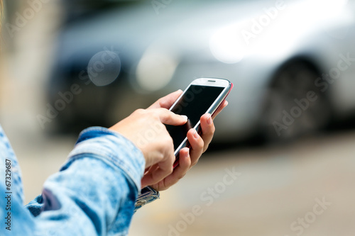 Mobile phone in a woman's hand. Outdoor image.