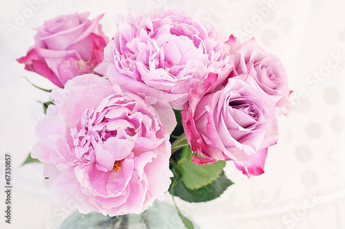 Close-up floral composition with a pink peony and roses