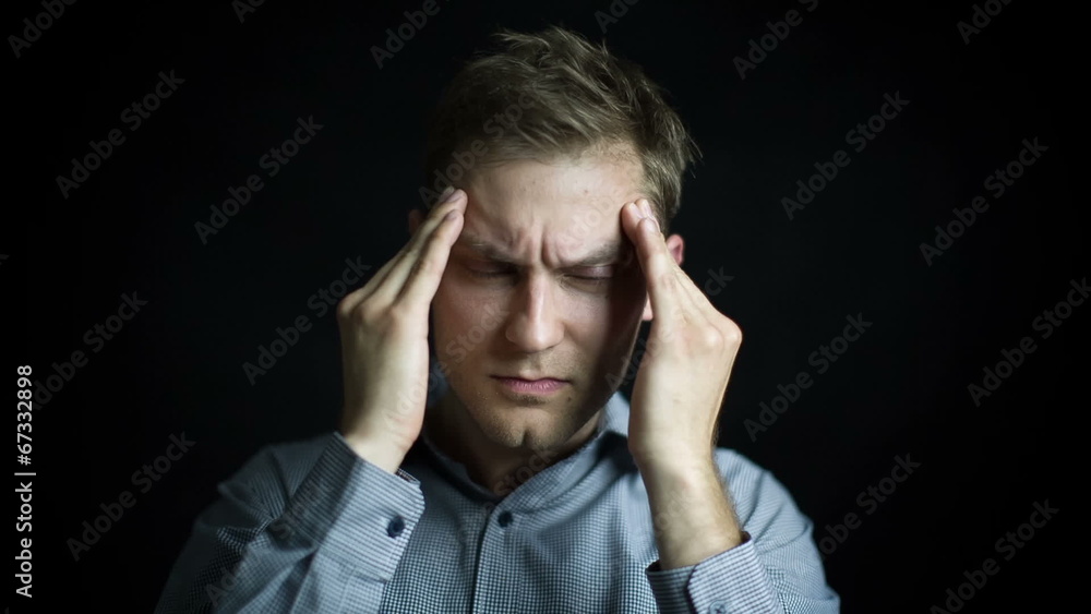 Portrait of stressed man with headache on black background Portrait of stressed man with headache on black background