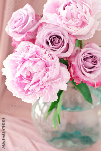 floral composition with a pink peony and roses .