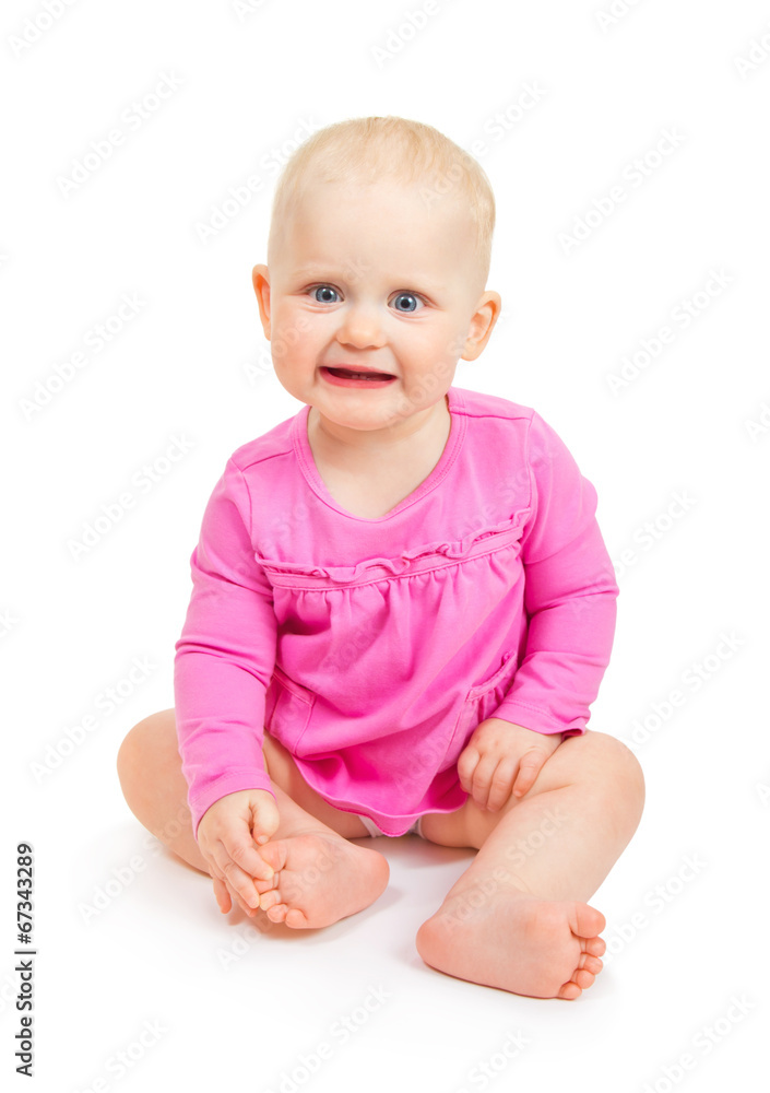The happy smiling girl in pink dress sits