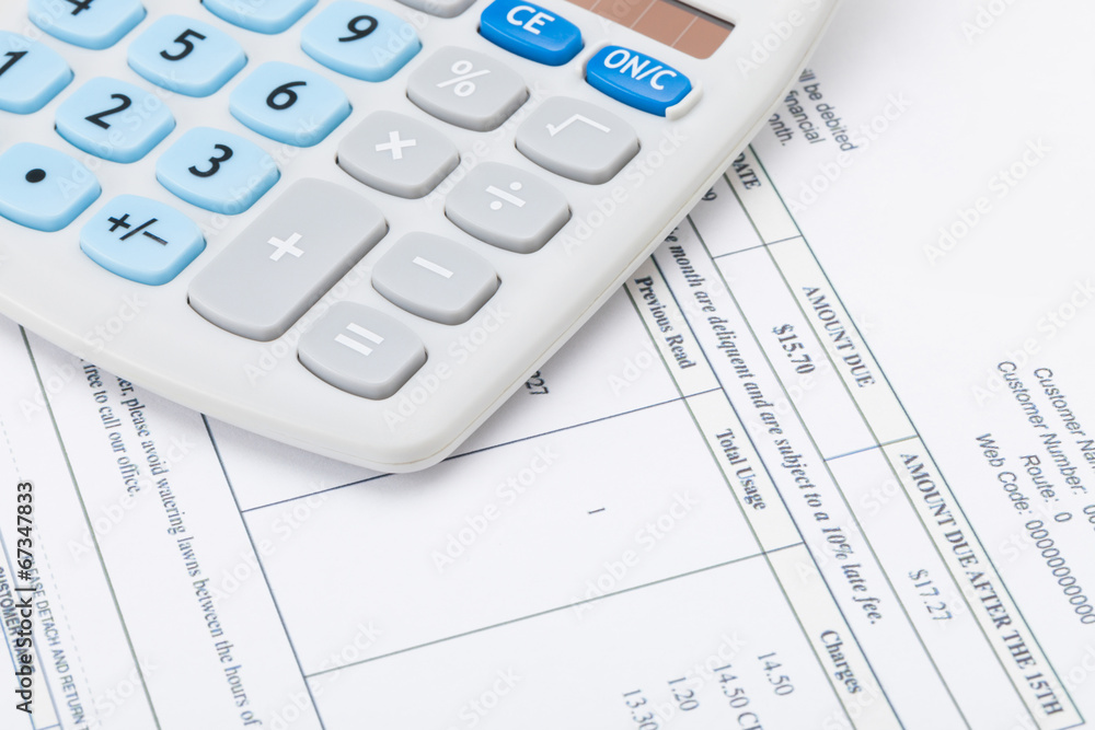 Studio shot of receipt next to calculator - studio shot Studio shot of receipt next to calculator - studio shot