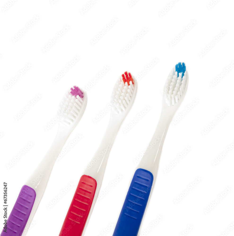 Three toothbrushes of different colors on white Three toothbrushes of different colors on white