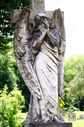 stone statue on winged female angel in cemetery